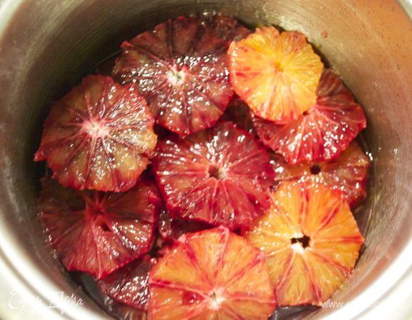 Выложить в сироп кружочки апельсинов и аккуратно перемешать, чтобы они покрылись сиропом.  