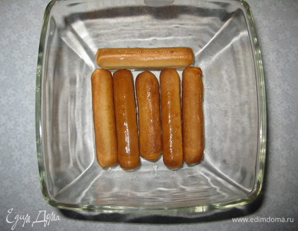Взять форму и на дно выкладываем пропитаное печенье.