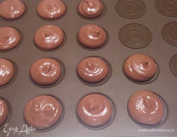 Отрезать нижний край мешка и отсадить печенья на специальный коврик для макарон. Можно использовать пергамент или обычный силиконовый коврик. Коврик просто помогает угадать с размером печенья, но еще советуют для новичков рисовать круги на пергаменте. Пока у меня не было коврика, я отсаживала без кругов, просто из лени. И думаю, что именно этот факт помог мне набить руку. Скажу одно, главное все делать смело и уверенно, иначе никакие круги не помогут.