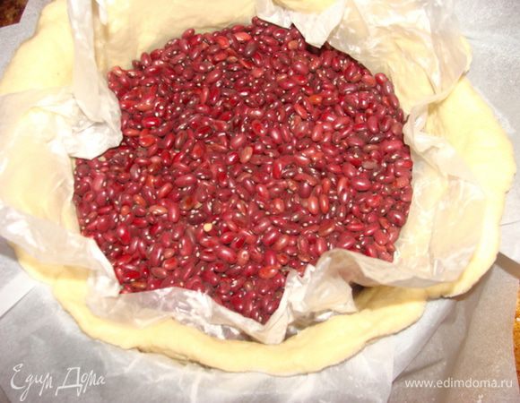 Сверху накрыть пекарской бумагой или фольгой, Я ее еще смазала маслом растительным со стороны контакта с тестом. Сверху выложить фасоль или горох. Это нужно, чтобы тесто во время выпекания не потеряло форму.