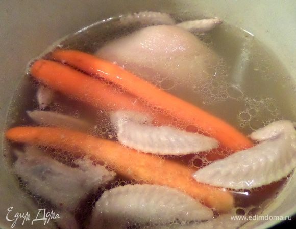 Примерно через 1,5-2 часа варки рульки добавляем крылышки и морковку. Подливаем воды.