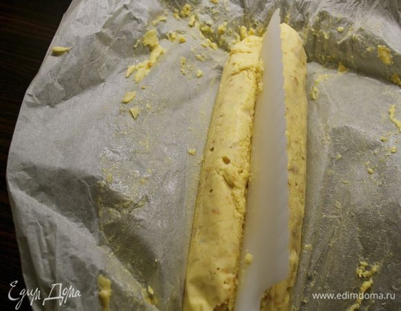 Через 40 минут достать сверток из морозилки, осторожно развернуть и с помощью продолговатого предмета (обратной стороной лезвия ножа, например) сделать углубление на поверхности бруска... Затем снова завернуть в бумагу, перевернуть и сделать руками небольшое "заострение", наподобие нижней части сердечка... Убрать сверток снова в морозилку. 