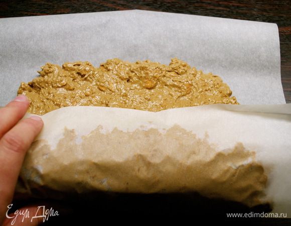 Помогая себе свободными концами бумаги снова как следует завернуть салями, плотно зажимая со всех сторон. Закрепить концы бумаги на подобие конфеты.  