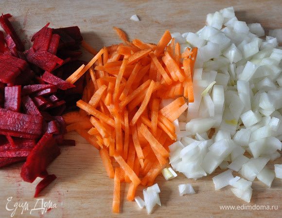 Очистить и порезать картофель дольками. Бросить в бульон. Порезать очищенные морковь, лук и свеклу соломкой. Бросить следом в бульон.