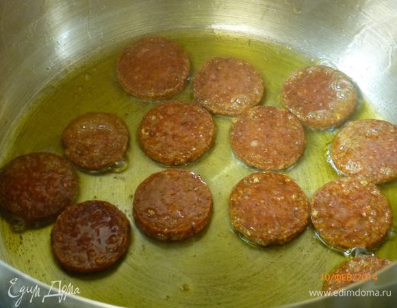 Чоризо нарезаем кружочками и обжариваем в кастрюле с толстым дном до золотистого цвета. При необходимости можно добавить оливковое масло (я не добавляла). 