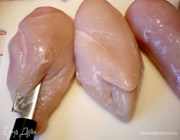 Грудки помоем, оботрем бумажным полотенцем, посолим, поперчим, прорежем сверху карман так, как показано на фото. Наполним начинкой и закрепим карман двумя зубочистками. Поджарим грудки в разогретом оливковом масле в течение 15 минут со всех сторон.