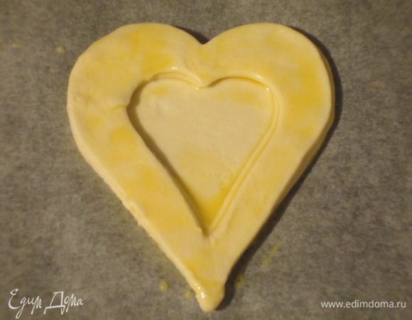 На каждое такое сердечко выложить по 2 полых, смазывая края яйцом. Дно волованов наколоть вилкой. Выпекать в разогретой до 200 °С духовке 10 минут. Остудит на решётке.