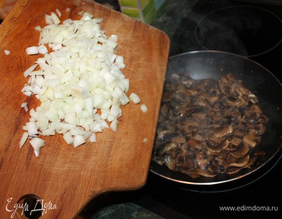 Луковицу почистить, порезать мелкими кубиками. С шампиньонов жидкость ушла, они начинают поджариваться - добавляем лук. Перемешиваем.