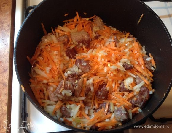 Добавляем к мясу, нашинкованный лук и порезанную соломкой морковку. Тушим помешивая мин 10.