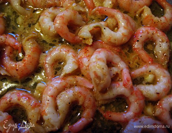 Растопить масло на сковороде на среднем огне. Когда оно растает - добавить креветки, мелко нарезанный чеснок и паприку. Жарить около 2-3 минут. 