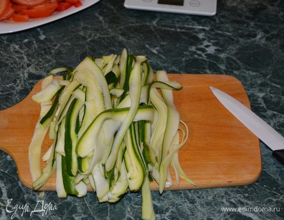 Пока помидоры и перец тушатся, цукини нужно тонко нарезать соломкой. Я для этого использую овощерезку, а широкие кусочки дополнительно разрезаю ножом.