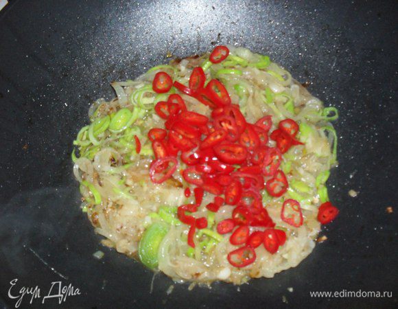 Острый перец чили очищаем от семян, режем колечками и добавляем в сковородку. Продолжаем тушить.