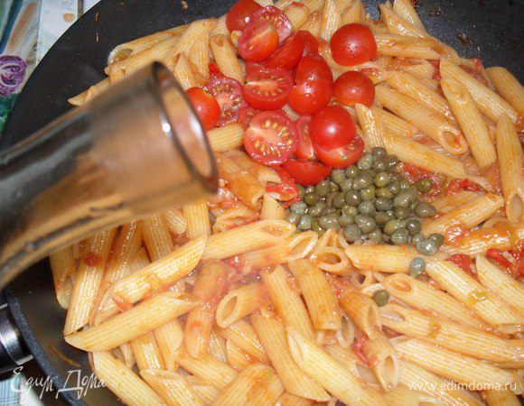 Помидоры чери режем пополам, кидаем в сковородку, туда же каперсы и рюмочку граппы. Все перемешиваем и держим под крышкой 2-3 мин. Паста готова. Подавать с зеленью петрушки и густо посыпав пармезаном.