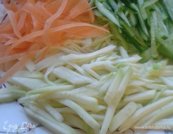 Разорвите листья салата и положите их в салатницу. Нарежьте  мелкой соломкой цукини, очищенный огурец. Морковь можно нарезать «чистелкой»  для овощей, так же можно нарезать сыр. Приготовьте заправку: соедините оливковое масло с лимонным соком  и приправьте солью, перцем, травами.