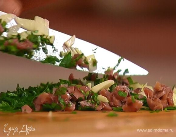 На рабочей поверхности соединить анчоусы, петрушку и чеснок и все вместе еще раз мелко порубить.