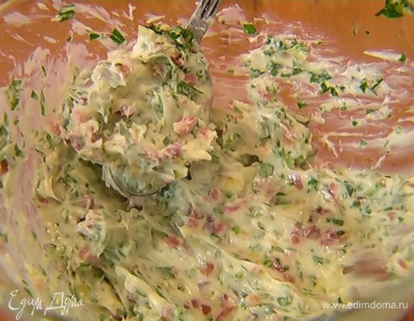 В предварительно размягченное сливочное масло добавить анчоусы с петрушкой и чесноком, все перемешать.