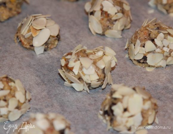 Теперь отщипываем от теста кусочки размером с грецкий орех, слегка катаем в ладошках в шарик, затем в миндальных крошках обваливаем и раскладываем на противне на расстоянии друг от друга 3 - 4 см. Печенье расплывется в духовке.