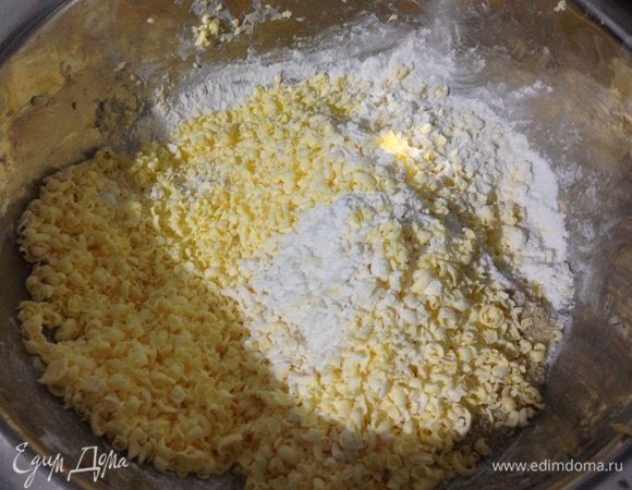 Смешать муку, соль, сахар, натереть на терке замороженное сливочное масло, периодически обваливая его в муке. Перемешать.