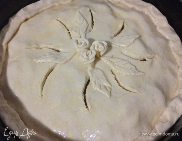 Второй кусок теста также раскатать. Можно раскатать побольше и обрезать по размеру формы, а из обрезков сделать цветочки. Накрыть яблоки и защипнуть края. Сверху сделать надрезы и по желанию украсить или оставить как есть. Смазать взбитым яйцом с молоком.