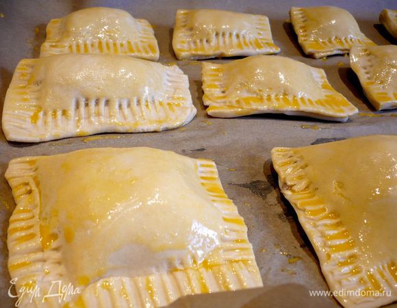 Пирожки наполняем начинкой, защипываем края и смазываем каждый пирожок желтком,  перемешанным с молоком. Выпекаем в духовке в течение 15 — 20 минут.    