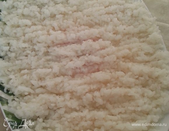После 15-ти минутного настаивания, выкладываем рис на широкое плоское блюдо, через плоскую лопатку (у меня - лопатка для риса от мультиварки) сразу же поливаем равномерно заправкой. Если есть комки, то разбираем их лопаткой (у меня их давно не было). Рис для суши и роллов готов!!!