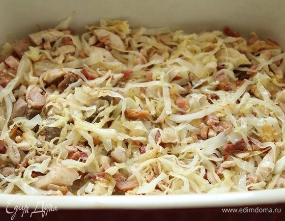 Пока тесто расстаивается, приготовить капусту. В сковородке разогреть пару ст. л. масла. Обжарить мелко нарезанный лук до прозрачности. Добавить копчености и обжарить с луком минуты 2. Добавляем капусту и тушить на небольшом огне в течение 30 минут.Выложить в форму.
