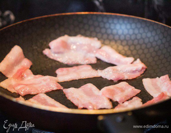 Разогреть сковороду и положить на неё бекон без масла. Обжаривать его 2-3 минуты до легкой румяности. 