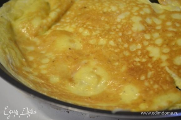 В большой сковороде разогреть масло и обжарить на нем яйца с обеих сторон. Получается яичный блинчик.