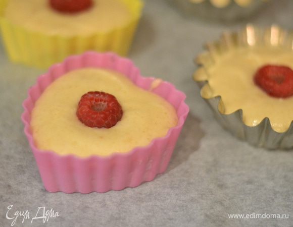 Тесто выложить в формочки,смазанные сливочным маслом,в серединку положить одну малинку.