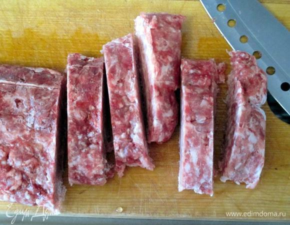 Забросила макарошки в воду, перемешала и пусть себе варятся. Нашинковала лук и начала его обжаривать на растительном масле чуть посолив. Фарш нарезала кусочками - кубиками. Хоть фарш и заморожен, но пласт толщиной около 1-1,5 см нетрудно порубить.