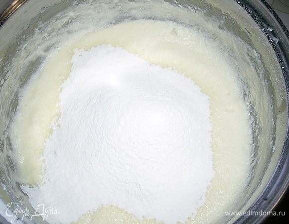 На полученную смесь просеиваем муку с крахмалом и перемешиваем лопаткой.