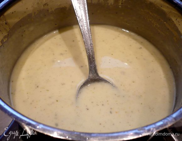 Теперь приготовим заливку для пирога. Разогреем в сотейнике сливочное масло, добавим муку, перемешаем до однородности, зальем горячий бульон и сметану, перемешаем, дадим закипеть, снимем с огня, посолим, поперчим, добавим два натертых зубчика чеснока.