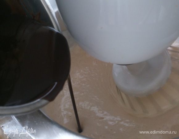 Перевести миксер на маленькую скорость и постепенно влить шоколадную массу.