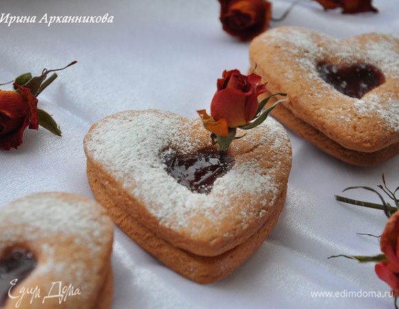 Раскатать тесто и вырезать формочками целое сердце и сердце с отверстием. Выпекать при 180 гр около 20-30 минут. Остывшие печеньки слепить джемом и посыпать пудрой.