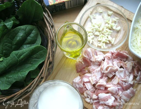 Бекон порезать на кусочки. Сыр натереть на крупной терке. Чеснок почистить и мелко порезать 2 зубчика. Листья базилика и шпината отделить от стеблей.