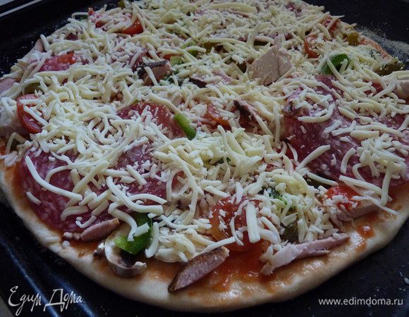 Смазываем основу томатным соусом и выкладываем желаемую начинку, затем тертую моцареллу. Следует помнить, что много соуса на пиццу класть не стоит, иначе он будет оттенять вкус начинки и самого теста. Обязательно сбрызнуть сверху оливковым маслом! Запекать 12 – 15 минут.