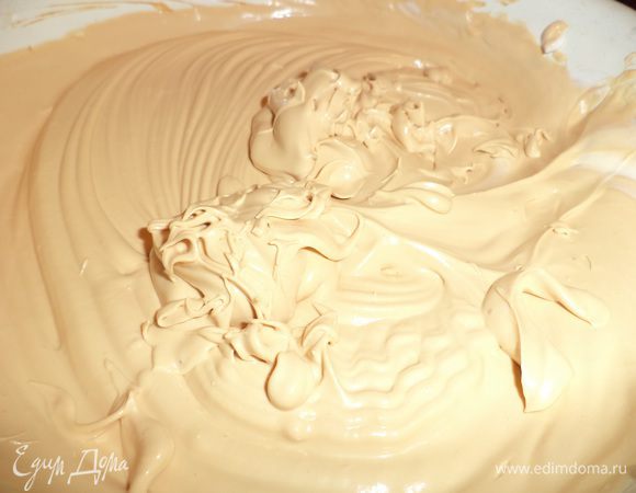 Понемногу добавлять взбитые сливки в сгущёнку, взбивая миксером.