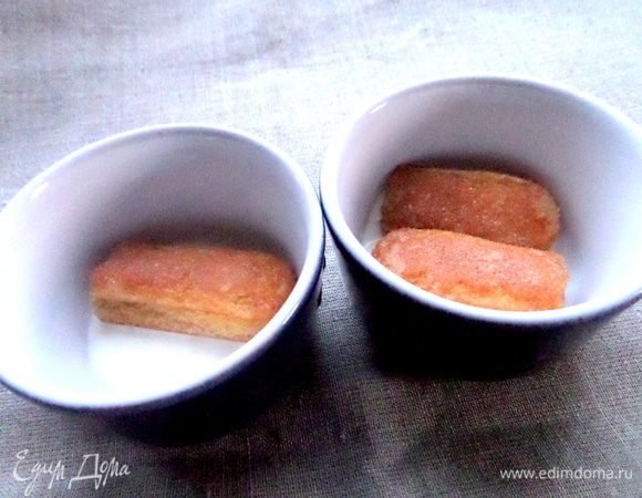 Макаем быстро кусочки печенья в остывший кофе и помещаем на крем.