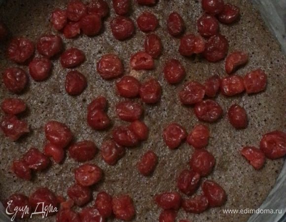 Перед выпечкой чизкейка, бока формы смазываем маслом и крепим на них пергамент, выкладываем бисквит на дно (он может немного усохнуть - не пугайтесь этого). Выкладываем вяленую вишню на бисквит, часть вишни оставляем для украшения.