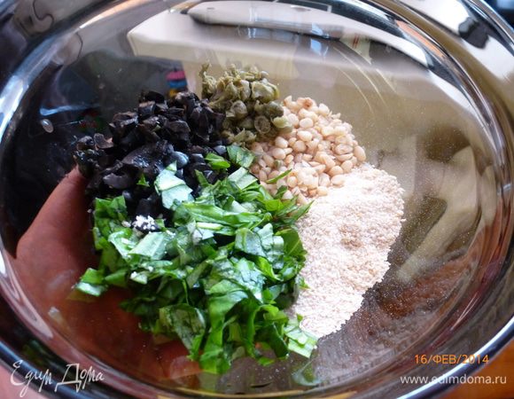 Готовим начинку для помидоров. Измельчаем маслины, каперсы, листья базилика и кедровые орехи. Добавляем молотые сухари. 