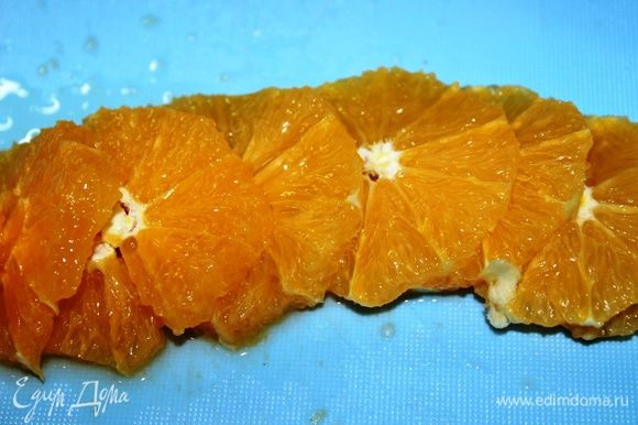 Снять острым ножом кожуру с апельсина и нарезать его на кругляшки.