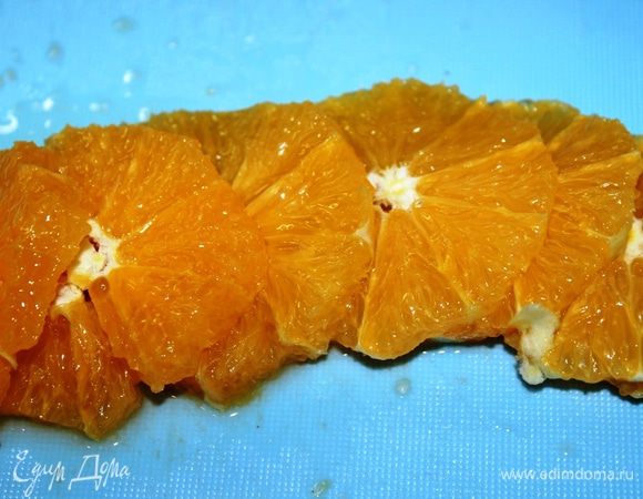 Снять острым ножом кожуру с апельсина и нарезать его на кругляшки.