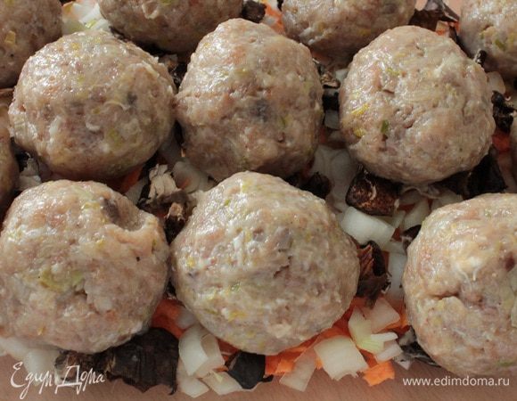 Мокрыми руками сформировать из фарша тефтели, выложить их поверх овощей.