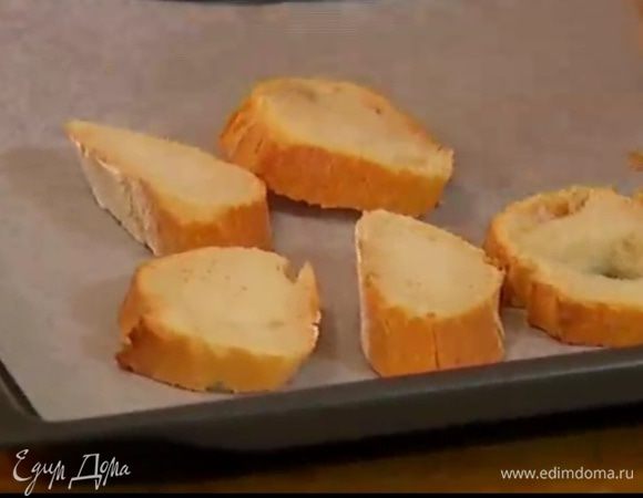 Багет нарезать кусочками и выложить на противень, выстеленный пекарской бумагой.