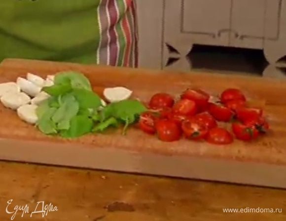 Моцареллу, помидоры и листья базилика посолить и поперчить на разделочной доске.