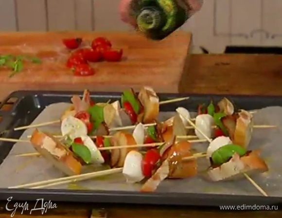 Сбрызнуть овощи и хлеб на шпажках оливковым маслом и отправить под гриль на 2–3 минуты.