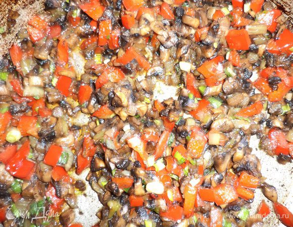 Слегка обжарить на растительном масле лук и шампиньоны, посолив и поперчив их. Добавить кубики перца, прожарить всё вместе. Добавить зелень, перемешать.