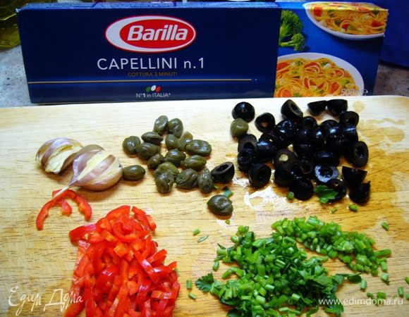 Т.к. процесс приготовления пойдет быстро, приготовим все ингредиенты: чеснок раздавим прямо в кожуре, оливки и перец чили порежем, нарежем стебли петрушки.
Поставим кипятиться воду для спагетти.
