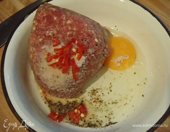 Фарш (у меня 50:50 свинина и говядина) смешать с яйцом, перцем чили, солью и черным свежемолотым перцем. Вмешать соду, она удерживает соки в мясе, ею можно заменить хлебную мякоть.