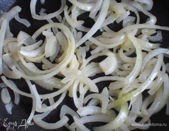 Лук нарезать тонкими полукольцами и обжарить на оливковом масле до золотистого цвета.